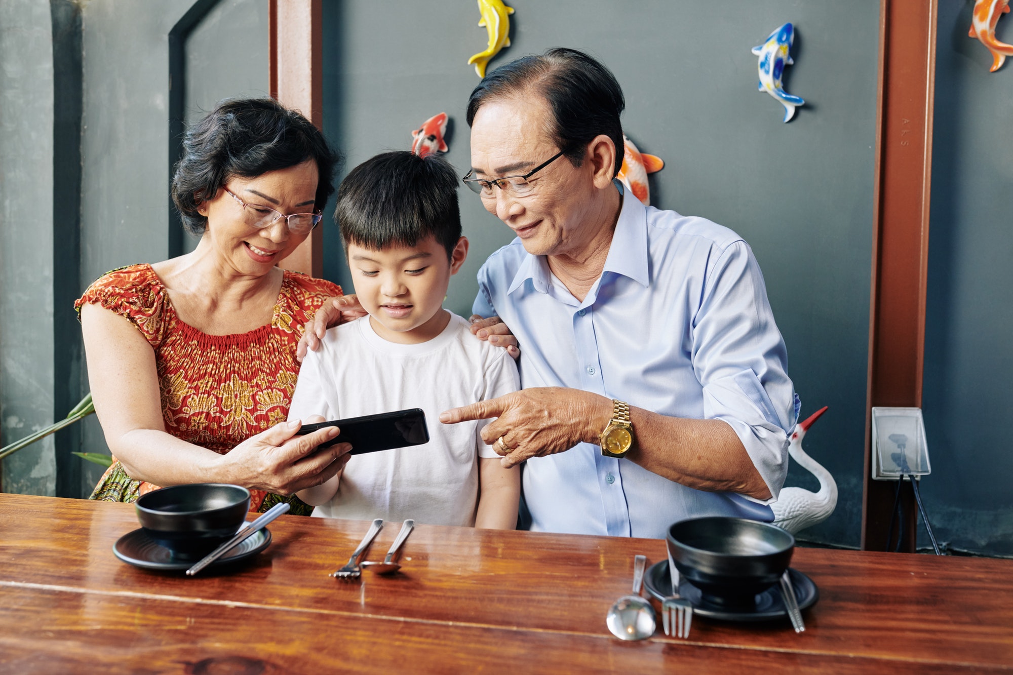 Senior people showing mobile app to grandson
